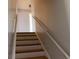 A well-lit staircase with wooden steps and white railings leads to the upper level of the home at 3300 Heritage Rd, Columbus, IN 47203