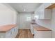 Bright kitchen featuring white cabinets, butcher block countertops, stainless steel sink, and wood-look flooring at 3505 Ralston Ave, Indianapolis, IN 46218