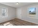 Bright, empty room featuring wood-look flooring and natural light from two windows at 3505 Ralston Ave, Indianapolis, IN 46218