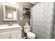 This bathroom has soft gray walls, white cabinets, and a shower with a patterned curtain at 3867 Asbury St, Indianapolis, IN 46227