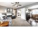 Open-concept living room with neutral colors, ceiling fan, and adjacent laundry area and dining space at 3867 Asbury St, Indianapolis, IN 46227