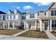 Street view of new townhouses with varied siding, inviting front porches, and tidy landscaping on a sunny day at 3923 Wren Dr, Brownsburg, IN 46112