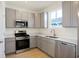 Modern kitchen featuring sleek gray cabinets, stainless steel appliances, and pristine white countertops at 3923 Wren Dr, Brownsburg, IN 46112
