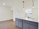 Bright kitchen view showing island with gray cabinets, quartz countertops, and modern pendant lighting at 3923 Wren Dr, Brownsburg, IN 46112