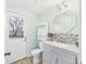 Bright bathroom featuring a modern vanity, decorative mirror, and direct access to the outdoors through a glass-paneled door at 411 W Memorial Dr, Muncie, IN 47302