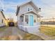 Charming home featuring gray siding, a bright blue front door, and a cozy covered porch, with a driveway leading to the street at 411 W Memorial Dr, Muncie, IN 47302
