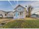 A cozy two-story house with gray siding, a quaint front porch, and a well-maintained lawn, perfect for a starter home at 411 W Memorial Dr, Muncie, IN 47302