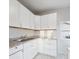Well-lit kitchen featuring white cabinets, granite countertops, stainless steel sink, and stylish tile flooring at 411 W Memorial Dr, Muncie, IN 47302