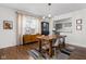 Open dining area featuring wood floors, a modern light fixture, and adjacent kitchen view at 4707 N Park Ave, Indianapolis, IN 46205