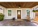 Inviting front porch featuring wood ceiling, stone floor, seating and wood door with glass at 4707 N Park Ave, Indianapolis, IN 46205