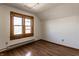 Bright bedroom featuring wood-look flooring, window with wood trim, and white walls at 4929 Young Ave, Indianapolis, IN 46201