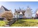 Charming home featuring a manicured lawn, tidy landscaping, and a cozy front porch sitting area at 4929 Young Ave, Indianapolis, IN 46201