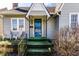 Close-up of a charming front porch featuring a decorative blue door, and a cozy seating area at 4929 Young Ave, Indianapolis, IN 46201