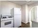 A well-lit kitchen featuring white appliances, shaker cabinets, and hardwood flooring at 4929 Young Ave, Indianapolis, IN 46201