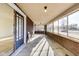 Long, spacious sunroom with brick walls, large windows, and concrete flooring at 518 Central S Ct, Indianapolis, IN 46205