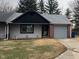 Charming single-story home with a tidy front yard and an attached one-car garage, nestled among mature trees at 5212 Mason Cir, Indianapolis, IN 46254