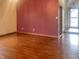 Inviting living room showcasing sleek, dark-stained wood floors and a fresh burgundy accent wall at 5212 Mason Cir, Indianapolis, IN 46254