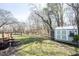 Large backyard with a shed, fire pit, and mature trees, offering a private outdoor space at 6149 W Country Ln, Anderson, IN 46011