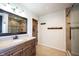 Bathroom with a wood vanity, decorative mirror, and tiled shower in the background at 6149 W Country Ln, Anderson, IN 46011