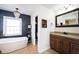 Bright bathroom with a soaking tub, shelf decor, and a wood vanity at 6149 W Country Ln, Anderson, IN 46011