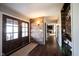Inviting entryway with hardwood floors, brick accent wall, and rustic wood door provides a warm welcome to the home at 6149 W Country Ln, Anderson, IN 46011