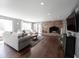 Spacious living room with a brick fireplace, hardwood floors, and an abundance of natural light at 6149 W Country Ln, Anderson, IN 46011