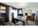 Bright home office featuring a large desk, black accent wall, and natural light from the window at 6149 W Country Ln, Anderson, IN 46011