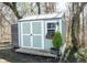 Charming shed with double doors, a window box with flowers, and a small tree, perfect for storage at 6149 W Country Ln, Anderson, IN 46011