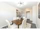 Dining area featuring a wood table, modern chairs, adjacent to hallway and staircase at 6216 N Woods Edge Ct, McCordsville, IN 46055