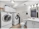 Bathroom with white cabinets, white toilet, and washer and dryer at 629 Williamsburg Ln, Greenwood, IN 46142