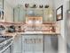 A charming kitchen featuring stainless steel appliances, decorative upper cabinets, and tiled backsplash at 6556 Aintree Ter, Indianapolis, IN 46250