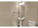 A well-lit powder room with a pedestal sink and tile flooring at 6806 Powder Dr, Indianapolis, IN 46259