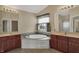 Primary bathroom featuring double vanities and a luxurious soaking tub under a window at 6806 Powder Dr, Indianapolis, IN 46259