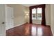 Cozy bedroom features a bright window with red curtains and hardwood flooring at 6806 Powder Dr, Indianapolis, IN 46259