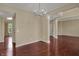 Bright dining room with elegant chandelier and rich, dark hardwood flooring at 6806 Powder Dr, Indianapolis, IN 46259