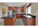 A kitchen equipped with wooden cabinets, stainless steel appliances and a center island cooktop at 6806 Powder Dr, Indianapolis, IN 46259