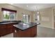 Kitchen island with cooktop, dark countertops, cabinetry and an adjacent breakfast area at 6806 Powder Dr, Indianapolis, IN 46259