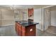 Kitchen island with black countertop and wood cabinetry, in an open-concept layout at 6806 Powder Dr, Indianapolis, IN 46259