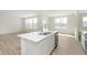 Spacious kitchen island with sink and stainless-steel dishwasher complements the adjacent, sun-lit living area at 6848 Jacone Dr, Brownsburg, IN 46112