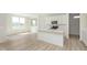 Bright, white kitchen with island, modern appliances, and wood-look flooring, bathed in natural light at 6848 Jacone Dr, Brownsburg, IN 46112