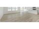 Spacious, light-filled living area next to a modern kitchen, all featuring beautiful wood-look flooring at 6848 Jacone Dr, Brownsburg, IN 46112