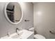 Modern bathroom with round mirror, sleek vanity, and glass-enclosed shower at 706 N Euclid Ave, Indianapolis, IN 46201