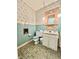 Retro aqua bathroom featuring matching toilet and sink with decorative wallpaper at 75 S 11Th Ave, Beech Grove, IN 46107