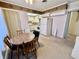 Cozy kitchen with white appliances, vintage wallpaper and adjacent breakfast nook with a round wooden table at 75 S 11Th Ave, Beech Grove, IN 46107