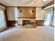 Charming living room with a brick fireplace, wood paneling, neutral carpeting and natural light at 75 S 11Th Ave, Beech Grove, IN 46107
