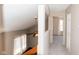 Hallway with neutral walls, leading to a bedroom with carpet and bright, natural light streaming through windows at 7837 Hunters Path, Indianapolis, IN 46214