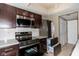 Modern kitchen with stainless steel appliances and dark wood cabinets at 7837 Hunters Path, Indianapolis, IN 46214