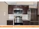 Modern kitchen with stainless steel appliances and dark wood cabinets at 7837 Hunters Path, Indianapolis, IN 46214