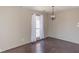 Inviting room featuring hardwood floors, a window and a modern light fixture at 7837 Hunters Path, Indianapolis, IN 46214