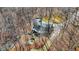Aerial view showcasing the home, lake, and surrounding wooded landscape at 7899 S Timber Cliff Ln, Trafalgar, IN 46181